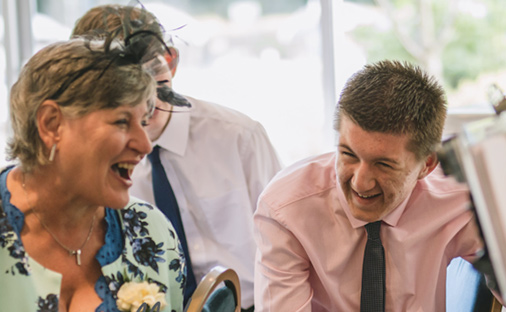 Mother and son laughing at there caricature at a Essex wedding