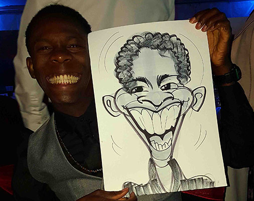 Big smile and all teeth as the subject poses with his caricature