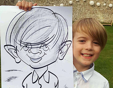 Child holding his caricature at Cissbury Barn