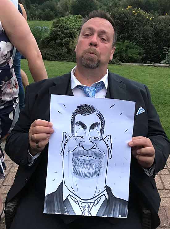 man shows off his caricature in ashford, kent