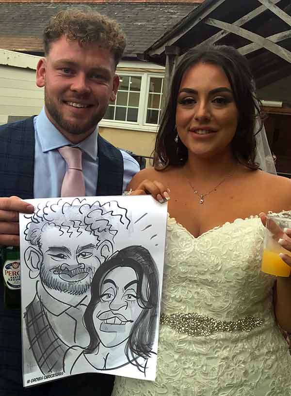 bride and groom pose with their caricature in west sussex