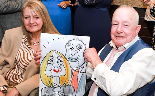 great wedding guests posing with their caricature at the Burfold hotel