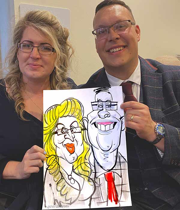 husband and wife pose for a photo with their caricature at Holiday inn