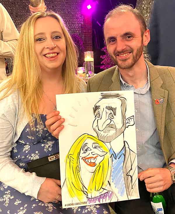 couple pose with a caricature at a Crawley event